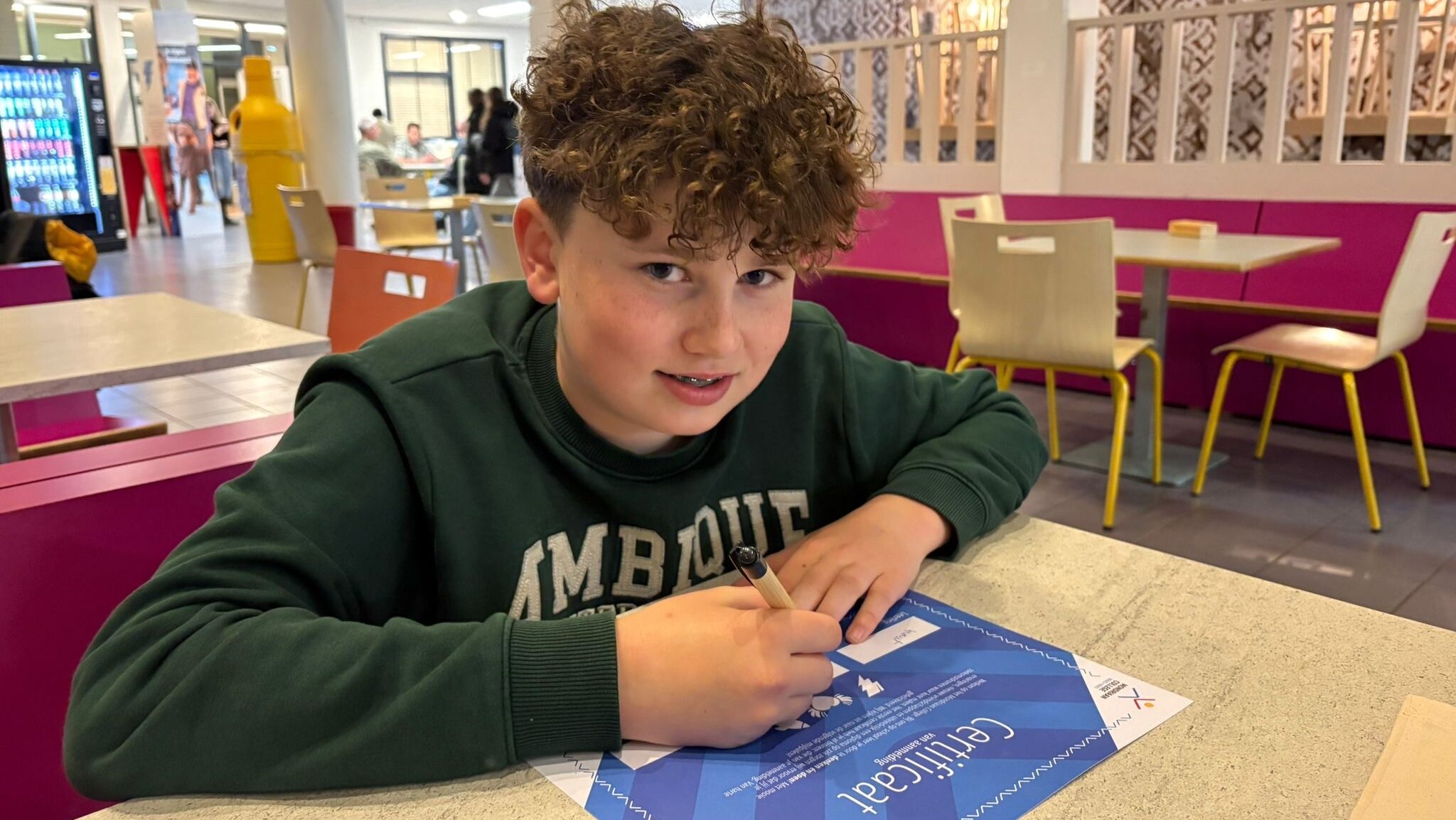 Toekomstig brugklasser Wout van Well ondertekent zijn aanmeldcertificaat op het Mondriaan College scholen